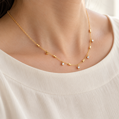 Crystal Station Necklace with clear crystal accents and gold-tone square bead details on a delicate chain, on a model