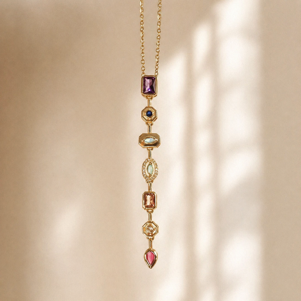 A gold-plated stainless steel chain for women featuring a vertical lariat pendant set with various colorful geometric stones