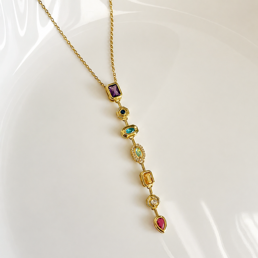 A gold-plated stainless steel chain for women featuring a vertical lariat pendant set with various colorful geometric stones
