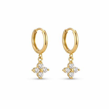 A pair of gold-plated hoop earrings for women featuring a sparkling four-petal crystal clover drop, shown on a white background.