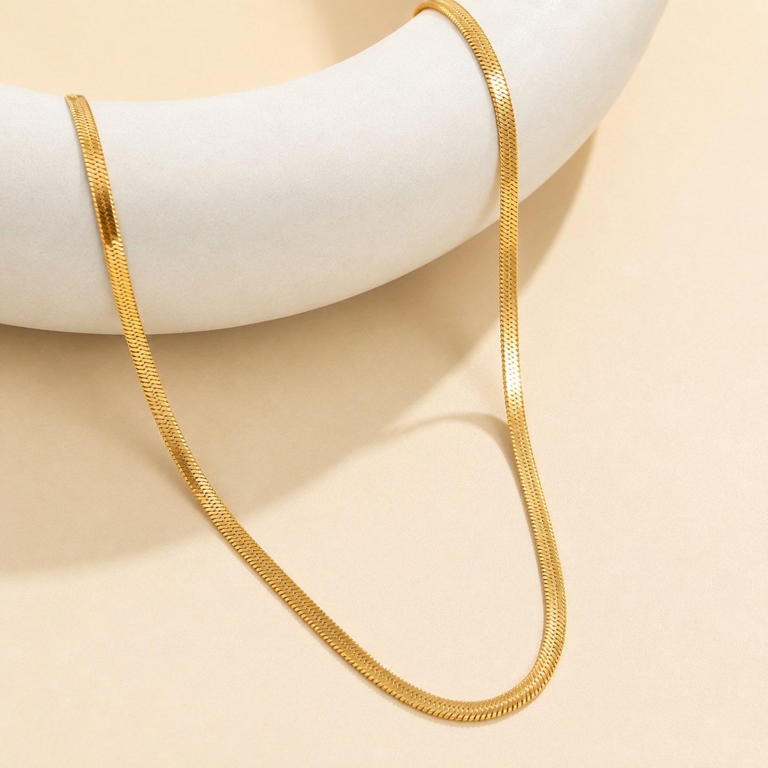 A gold-plated stainless steel chain for women featuring a high-shine, liquid-like flat snake chain layout.