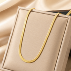 A close-view of a gold-plated stainless steel chain for women featuring a high-shine, liquid-like flat snake chain layout.