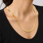 A gold-plated stainless steel chain for women featuring a high-shine, liquid-like flat snake chain layout, on a model