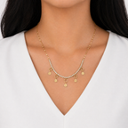 A gold-plated stainless steel chain for women featuring a crystal tennis-style necklace with five dangling hammered-gold coin charms, shown on a model