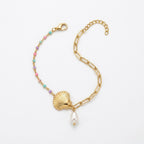 A gold-plated ladies bracelet featuring a gold paperclip chain on one side and a colorful beaded pearl strand with a shell charm on the other.