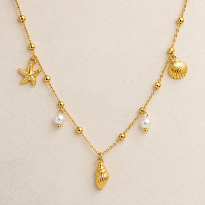 Coralie gold coastal necklace for women with shell, starfish and pearl charms on a delicate chain
