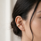 A gold-plated criss-cross double-band ear cuff earrings for women featuring interlinked smooth and pavé crystal bands on a model