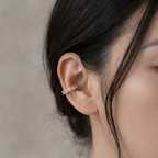 A gold-plated ear cuff earrings for women featuring five brilliant prong-set stones on a model
