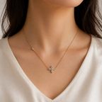 A gold-plated stainless steel chain for women featuring a four-petal crystal flower pendant and a side bezel-set crystal accent, shown on a model