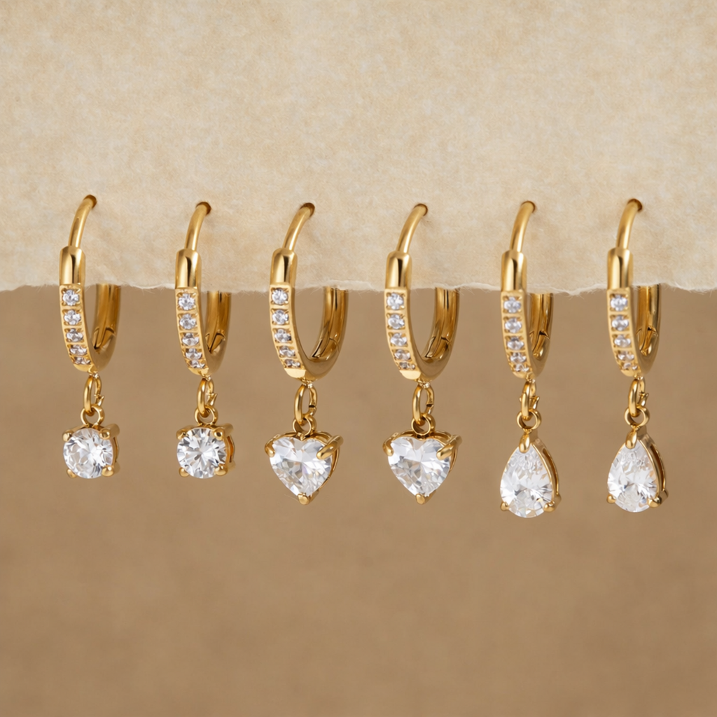 Gold earrings with clear stones on a display
