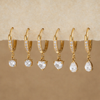 Gold earrings with clear stones on a display