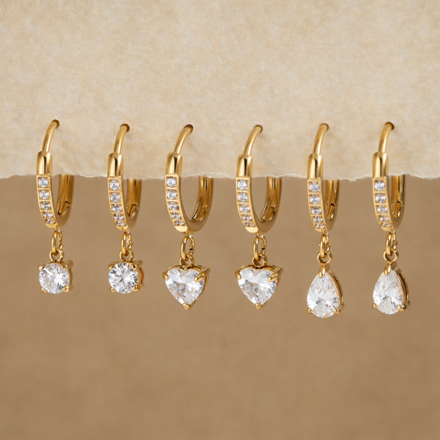 Gold earrings with clear stones on a display