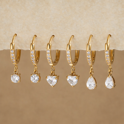 Gold earrings with clear stones on a display
