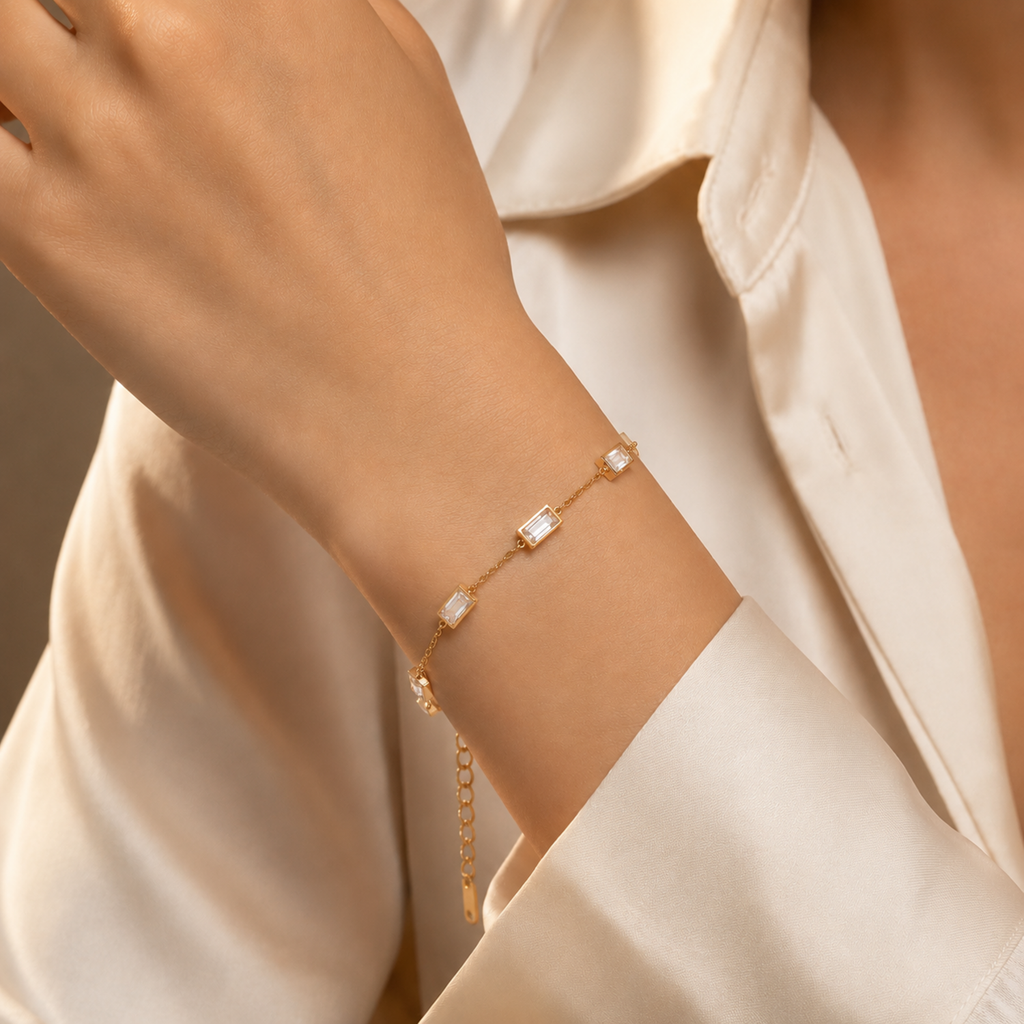 A close-view of a gold-plated stainless steel chain bracelet for women featuring five clear rectangular baguette stones.
