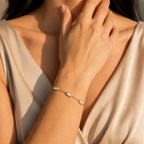 A gold-plated stainless steel chain bracelet for women featuring five clear rectangular baguette stones, shown on a model