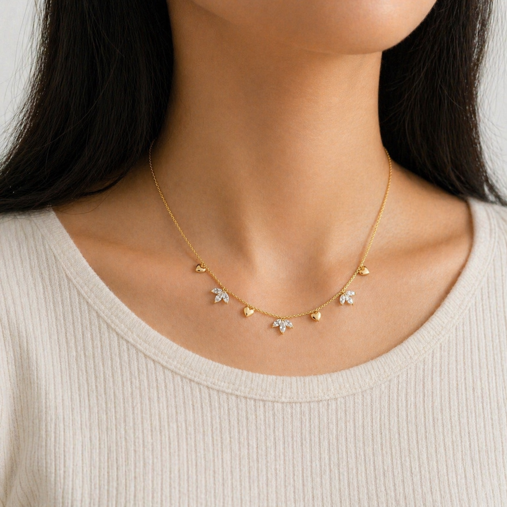 A gold-plated stainless steel chain for women featuring alternating gold heart charms and crystal floral clusters, shown on a model