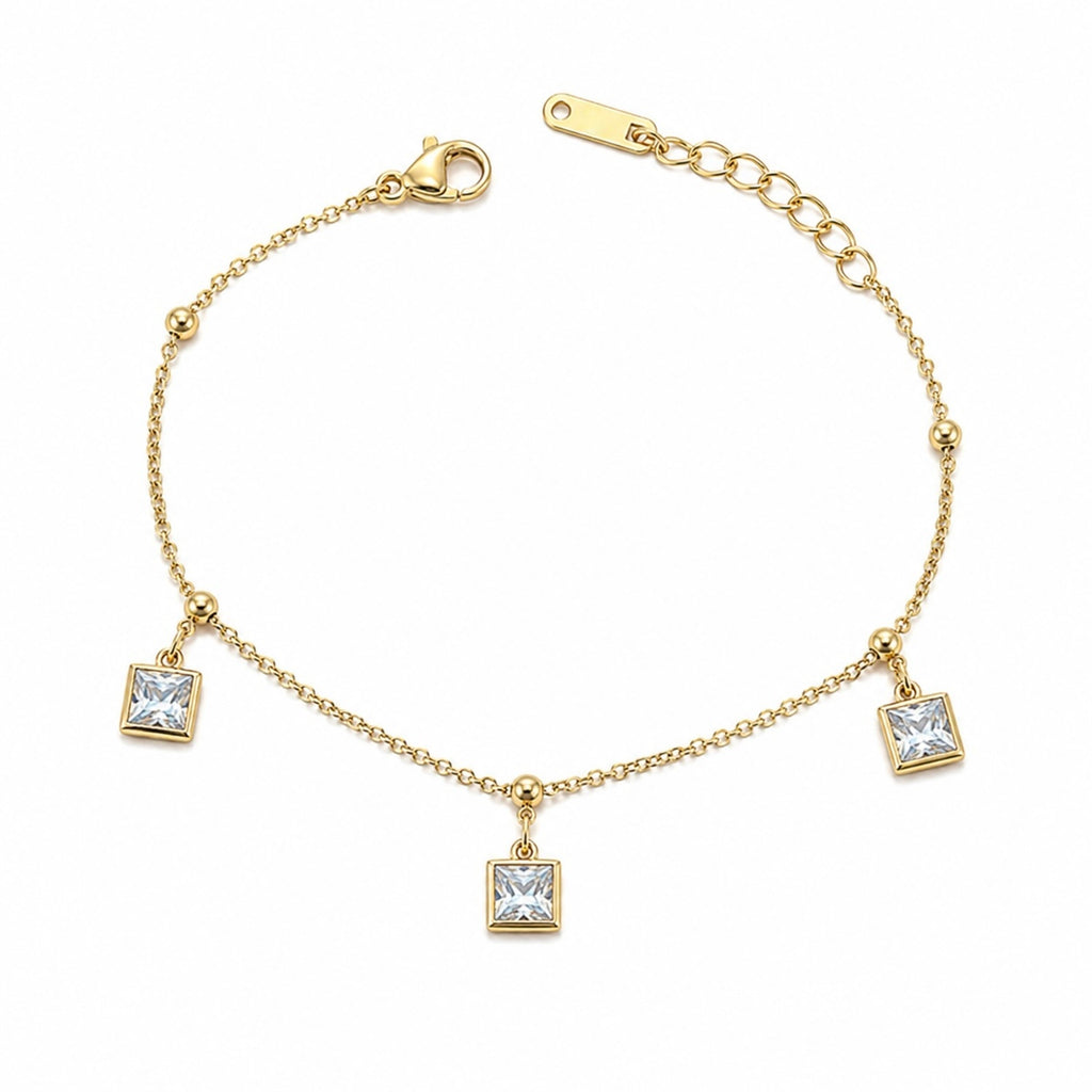 Gold bracelet with square crystal charms on a white background