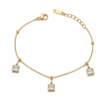 Gold bracelet with square crystal charms on a white background