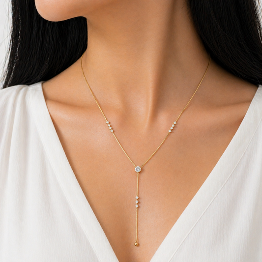 A gold-plated stainless steel chain for women featuring a Y-drop design with multiple crystal accents and a gold bead finish, shown on a model