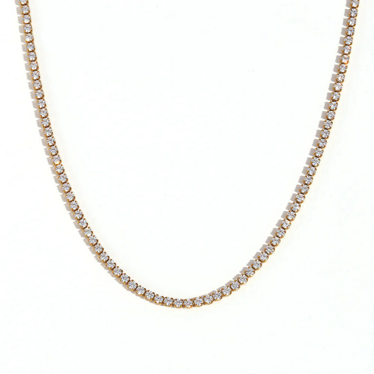 A gold tennis necklace on a white background