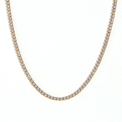 A gold tennis necklace on a white background