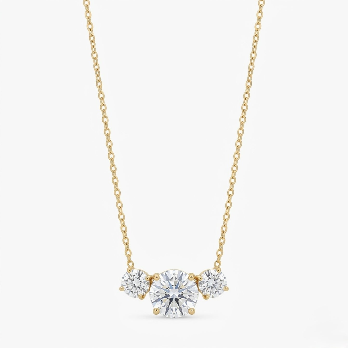 A gold-plated stainless steel chain for women featuring three graduated round-cut crystal stones.
