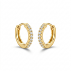 A pair of gold-plated huggie hoop earrings for women featuring a delicate row of clear crystals, shown on a white background