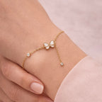 A dainty gold-plated chain bracelet for women featuring a white butterfly charm and crystal accents on a model