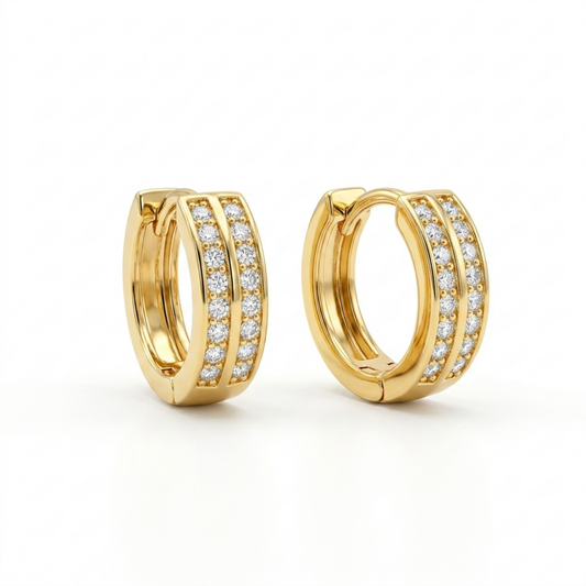 A pair of gold-plated huggie hoop earrings for women featuring a duo design set with clear crystals, shown on a clean white background.