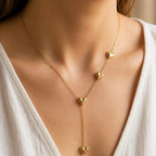 A gold-plated stainless steel chain for women featuring a Y-shaped drop design with four polished, 3D heart charms, shown on a model
