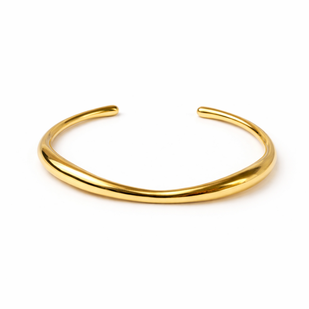 A minimalist gold-plated adjustable cuff bracelet for women featuring a slim, organic wave design on a white background