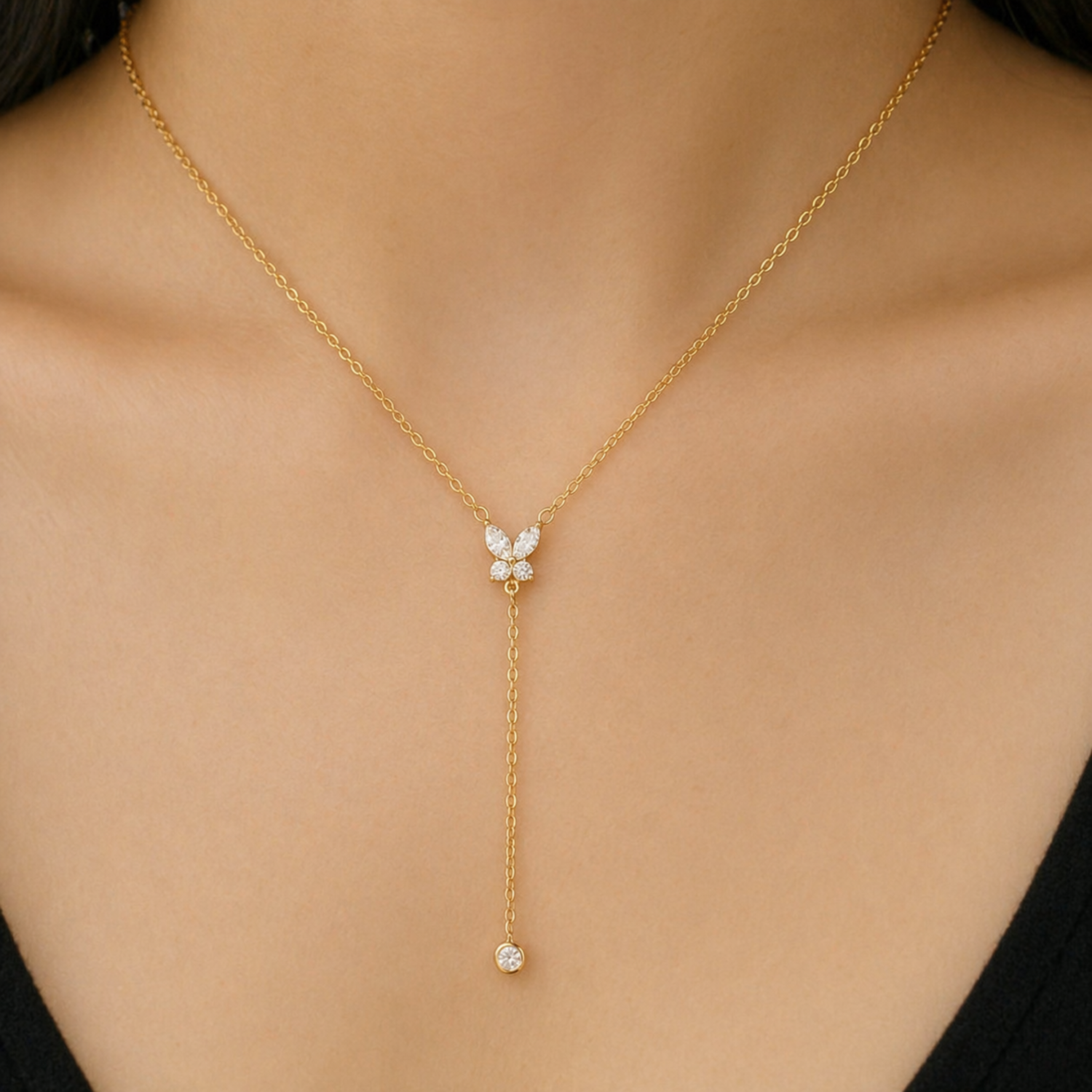 A close-view of a gold-plated stainless steel chain for women featuring a crystal butterfly lariat design with a plunging drop and solitaire stone
