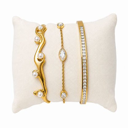 A three-piece gold-plated wrist stack for women featuring a minimalist open cuff, a solid polished kada, and a delicate bezel-set crystal chain bracelet.