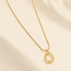 A close-view of a gold-plated stainless steel chain for women featuring a sleek snake link and a open-oval pendant
