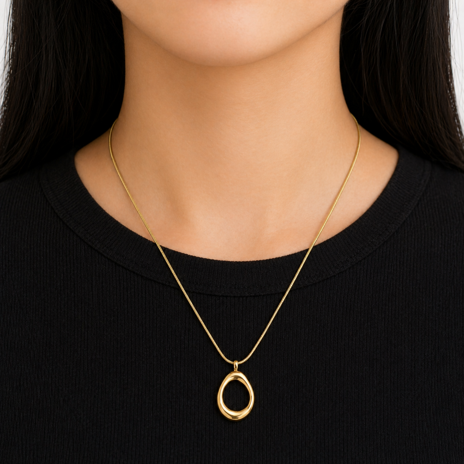 A gold-plated stainless steel chain for women featuring a sleek snake link and a open-oval pendant, shown on a model