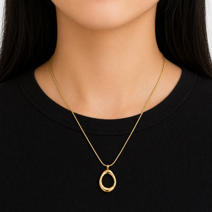 A gold-plated stainless steel chain for women featuring a sleek snake link and a open-oval pendant, shown on a model