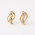 A pair of gold-plated wave-shaped huggie hoop earrings for women featuring a curved row of clear crystals, shown on a clean white background.