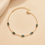 A gold-plated stainless steel chain bracelet for women featuring five rectangular emerald-green baguette stones.