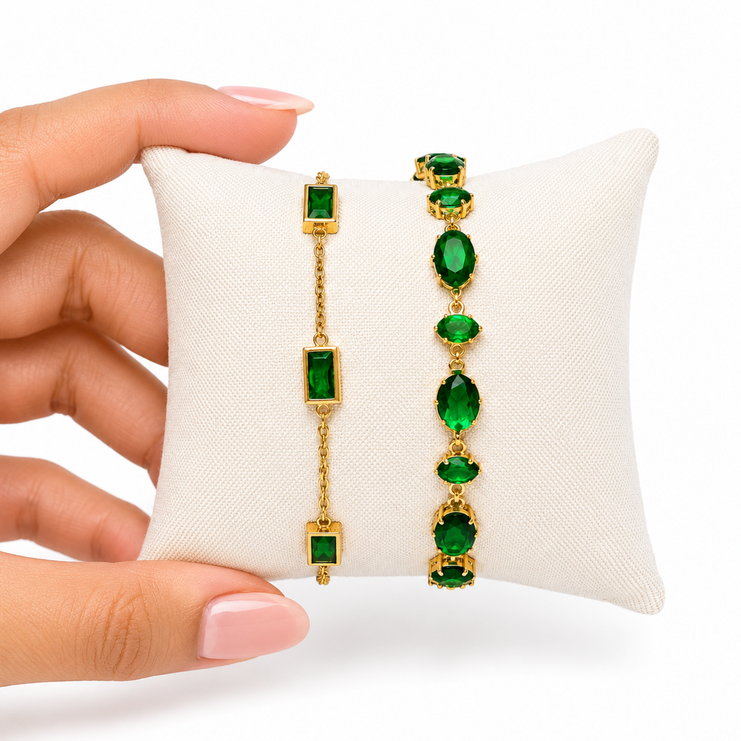 A close-view of a  premium two-piece gold-plated bracelet stack for women featuring the Emerald Horizon Baguette Bracelet and a matching faceted emerald green oval crystal chain bracelet.