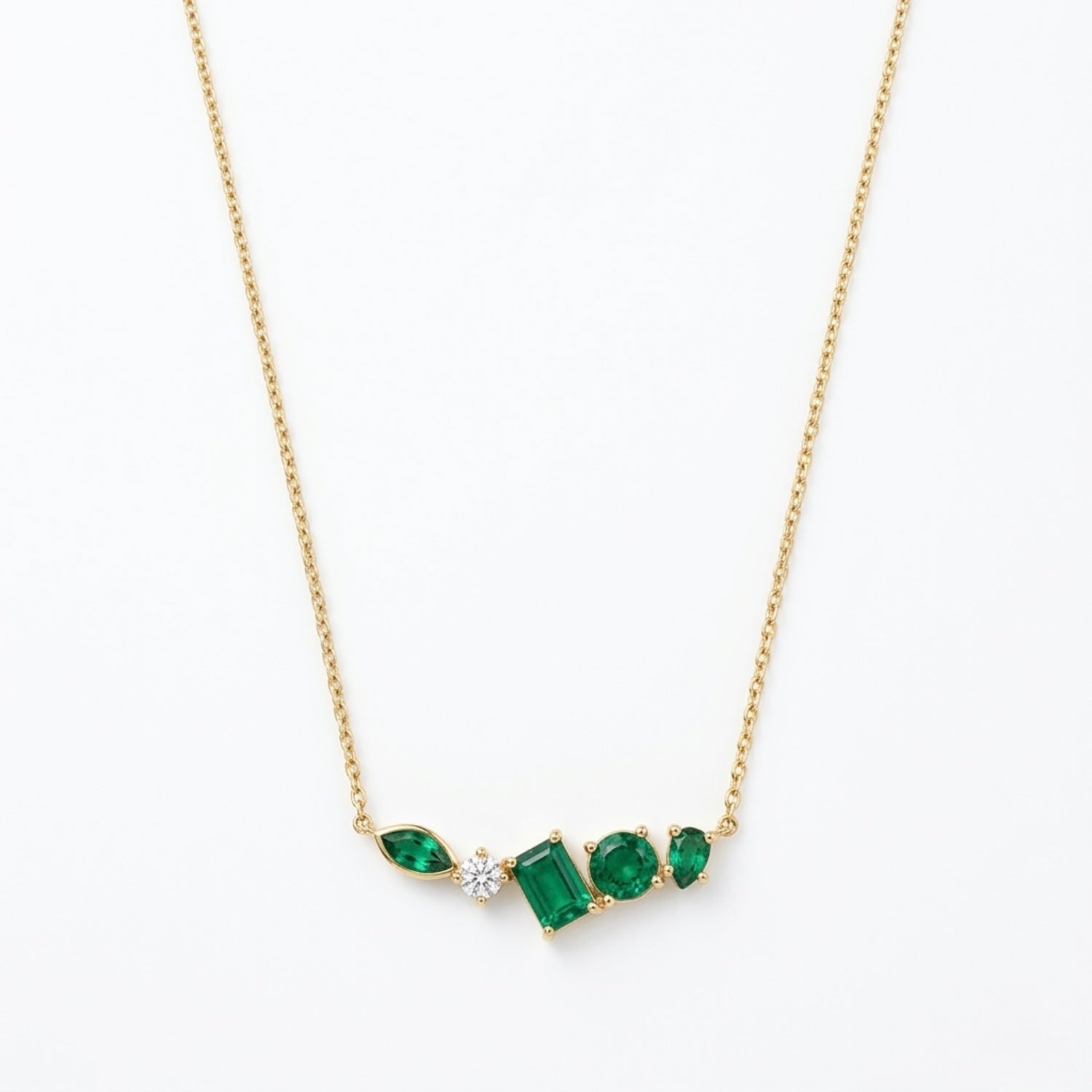 A gold-plated stainless steel chain for women featuring an asymmetrical pendant bar set with various emerald green and white crystal stones