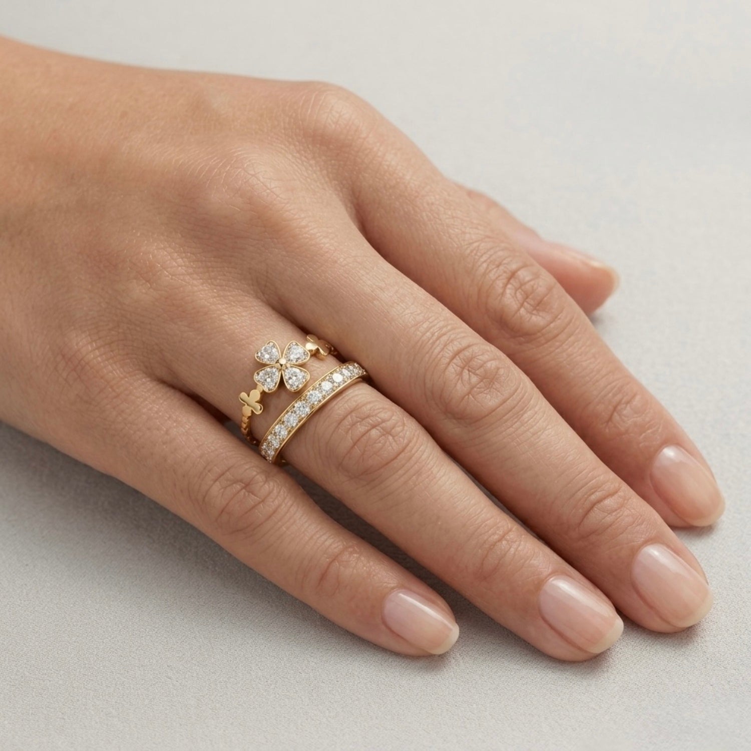 A luxurious gold plated adjustable ring for women featuring four-leaf clover motif and a second eternity band displayed on a model hand
