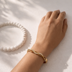 A high-quality gold-plated infinity braid bangle for women featuring pavé-set white stones on a model hand