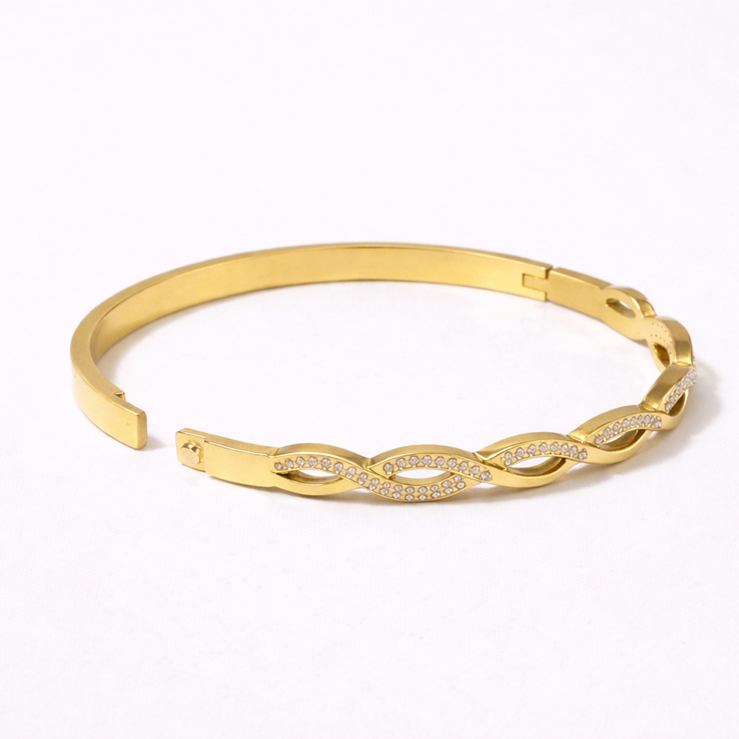 A side view of a high-quality gold-plated infinity braid bangle for women featuring pavé-set white stones on a white background