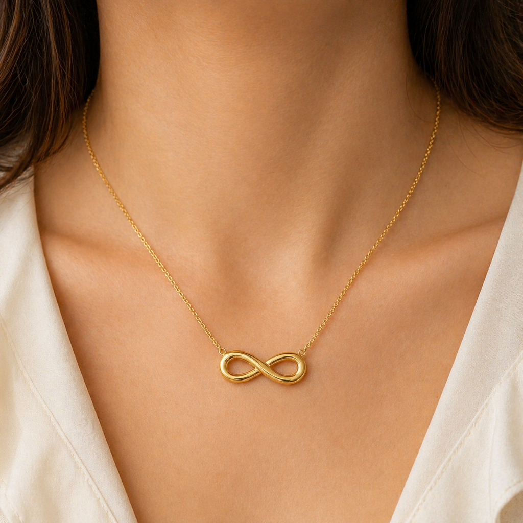 A gold-plated stainless steel chain for women featuring a infinity symbol pendant, shown on a model