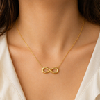 A gold-plated stainless steel chain for women featuring a infinity symbol pendant, shown on a model