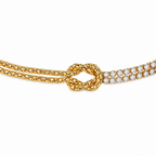 A close-view of a gold-plated chain bracelet for women featuring a central knot, one woven gold strand, and one double-row crystal strand.