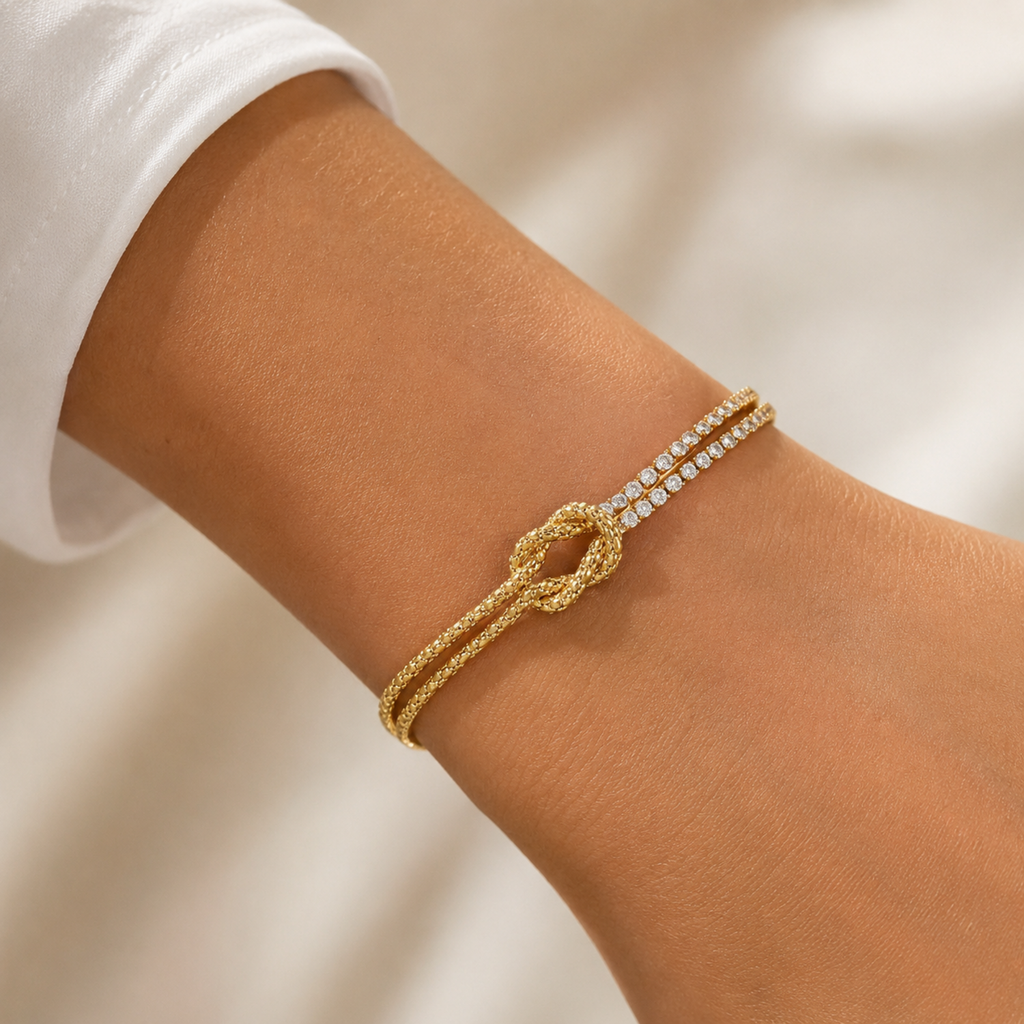 A gold-plated chain bracelet for women featuring a central knot, one woven gold strand, and one double-row crystal strand, shown on a model