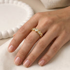 A gold plated adjustable eternity ring for women featuring a continuous row of heart-shaped white stones, displayed on a model hand