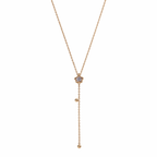 A gold-plated stainless steel Y-shaped necklace for women featuring a small crystal flower pendant and a dangling chain with gold beads, shown on a white background