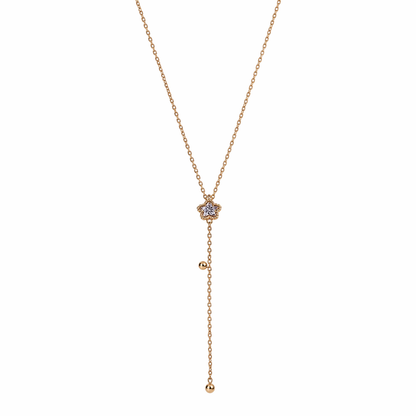 A gold-plated stainless steel Y-shaped necklace for women featuring a small crystal flower pendant and a dangling chain with gold beads, shown on a white background